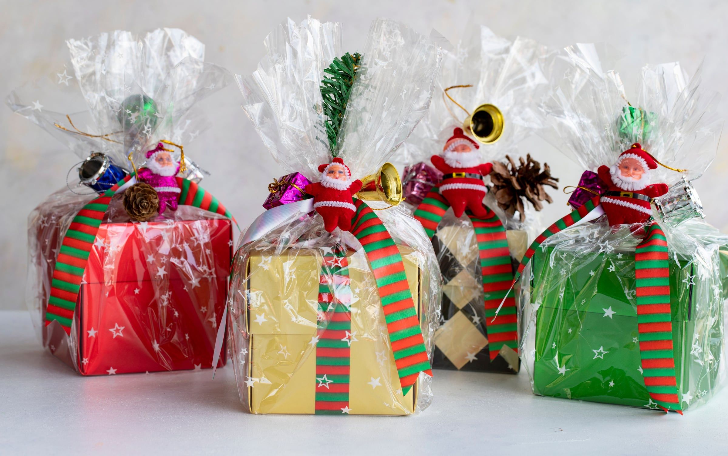 Assorted gift boxes wrapped in cellophane with ribbons and seasonal details