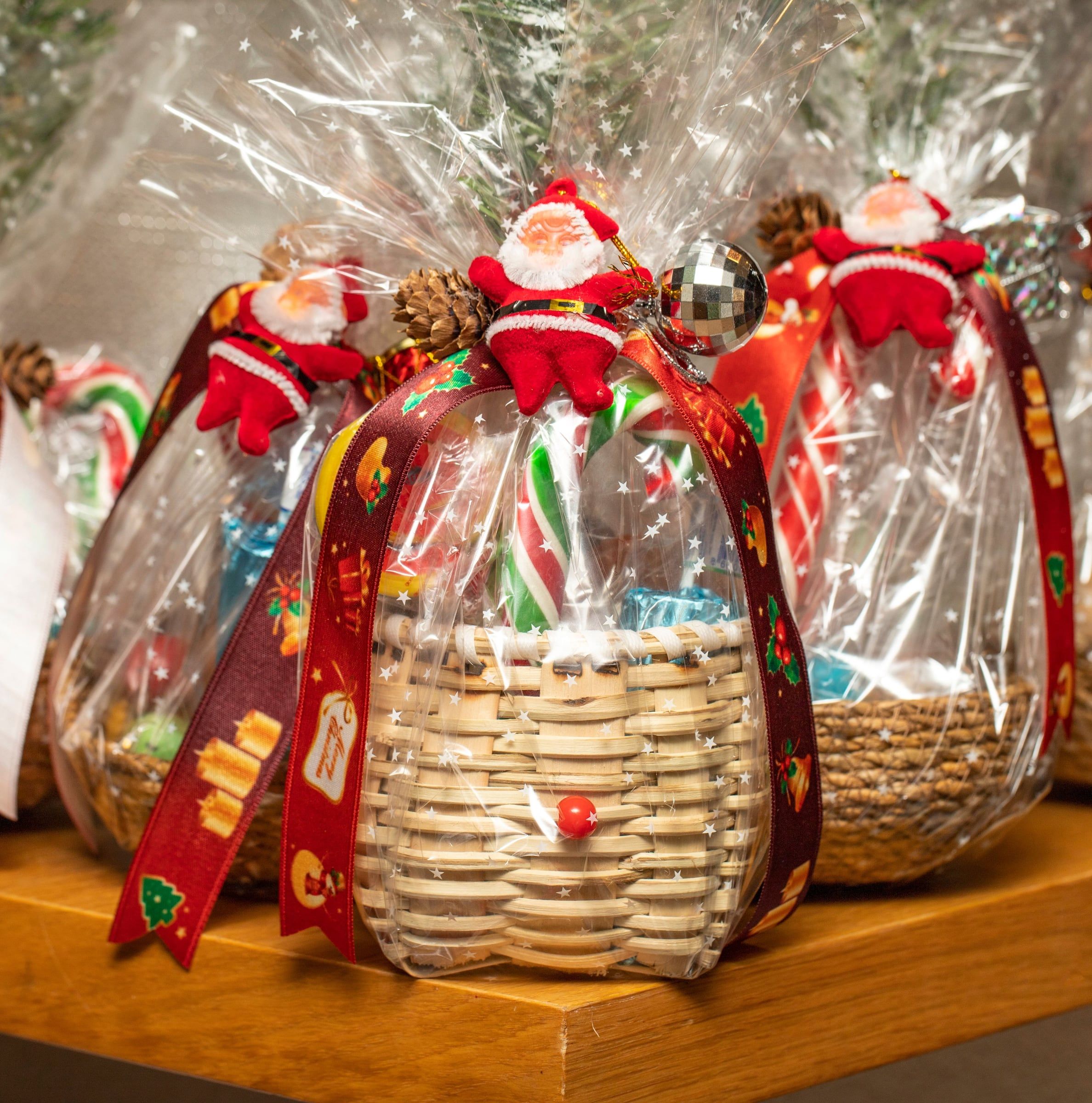 Holiday gift baskets wrapped in cellophane with ribbons and sweets for employees