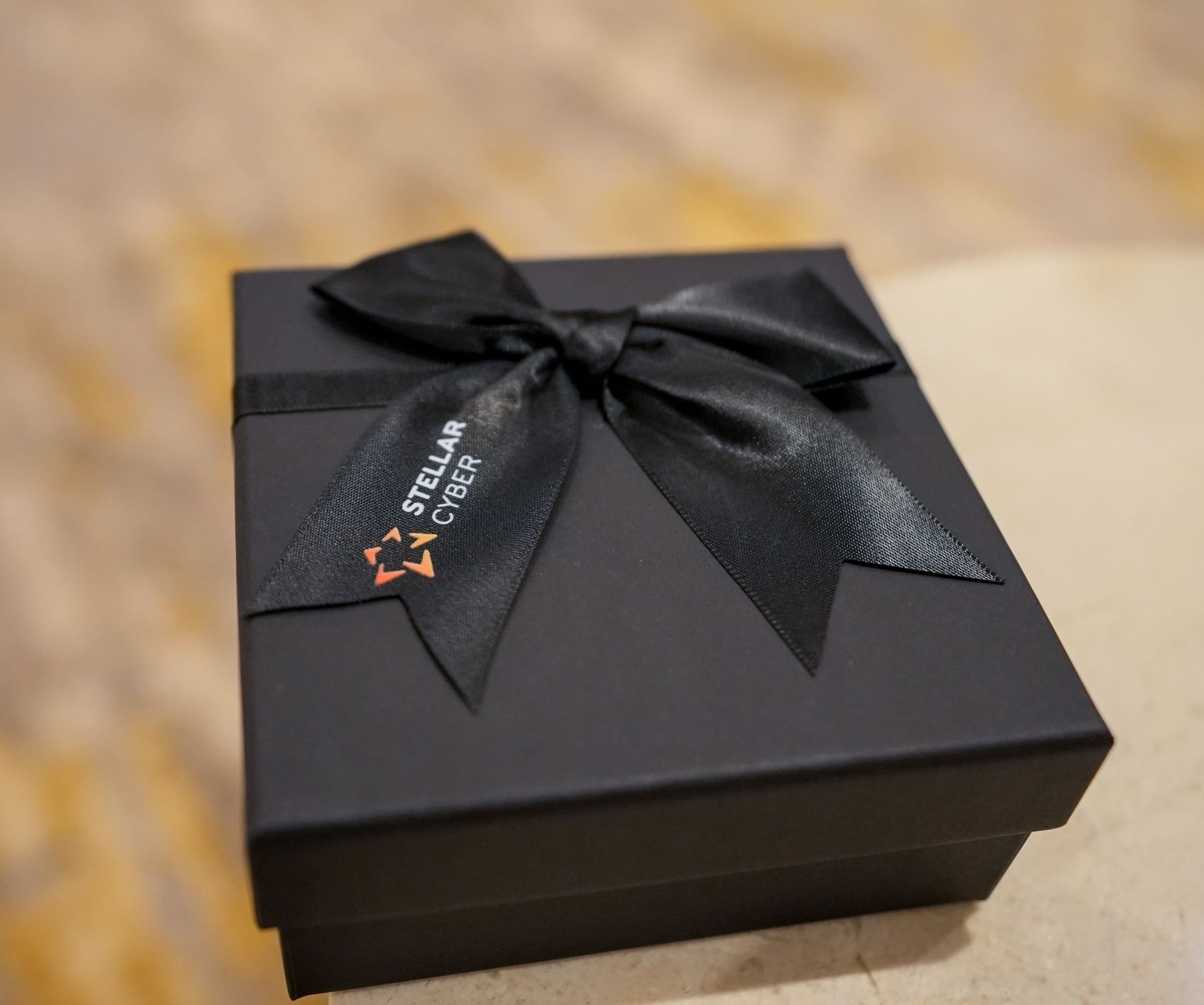 Caja rígida negra con cinta satinada impresa con el logo de la empresa cliente